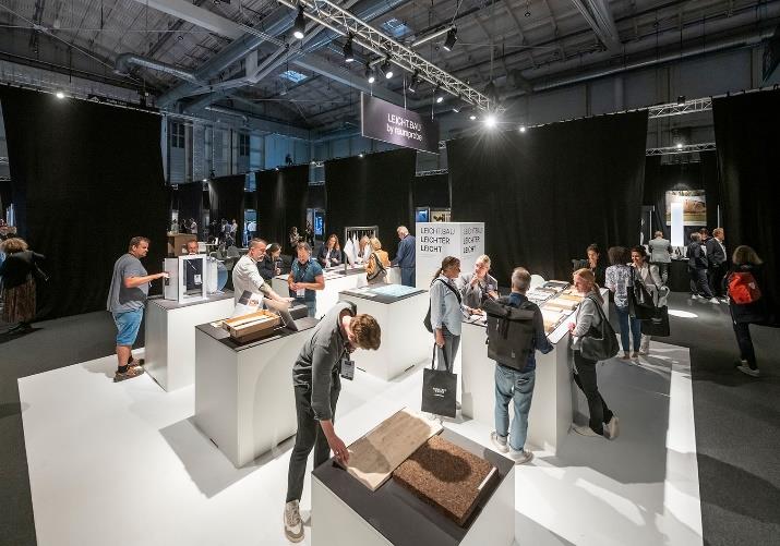 eine gruppe von menschen schaut sich während einer architect@work einladungsveranstaltung in düsseldorf bücher in einem raum an.