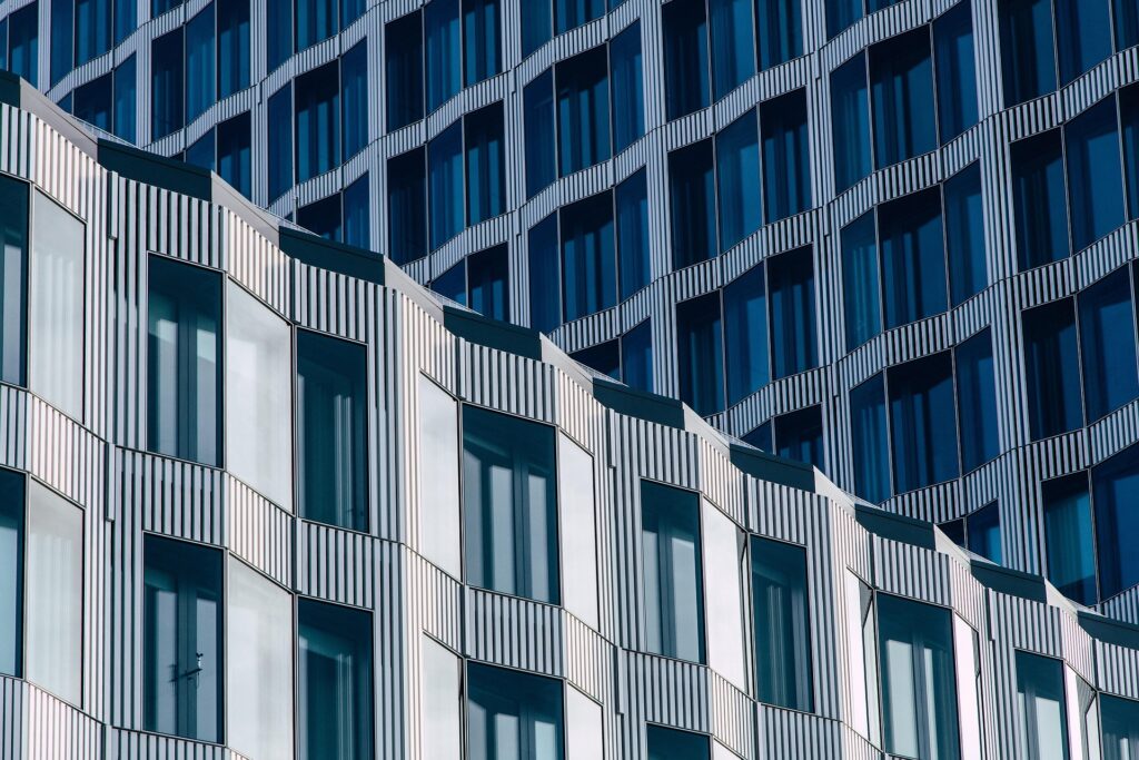 Nahaufnahme einer modernen Gebäudefassade mit sich wiederholenden geometrischen Mustern, vertikalen Linien und Glasfenstern, die das Licht reflektieren - ein beeindruckendes Design, das bei den Architizer A+ Awards 2025 ausgezeichnet wurde.