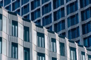 Nahaufnahme einer modernen Gebäudefassade mit sich wiederholenden geometrischen Mustern, vertikalen Linien und Glasfenstern, die das Licht reflektieren - ein beeindruckendes Design, das bei den Architizer A+ Awards 2025 ausgezeichnet wurde.