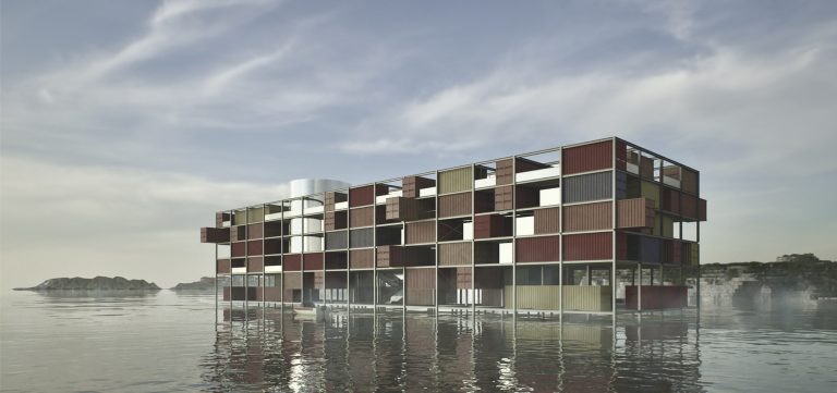 Ein modernes, rechteckiges, mehrstöckiges schwimmendes Bauwerk, das an ein Museum in Containern erinnert, hat eine gitterartige Fassade aus farbigen Paneelen und ruht auf ruhigem Wasser mit einer felsigen Küste im Hintergrund.
