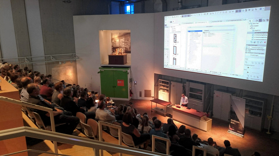 Eine Gruppe von Menschen in Dortmund schaut sich in einem großen Auditorium eine Präsentation über ARCHICAD 22-Updates an.