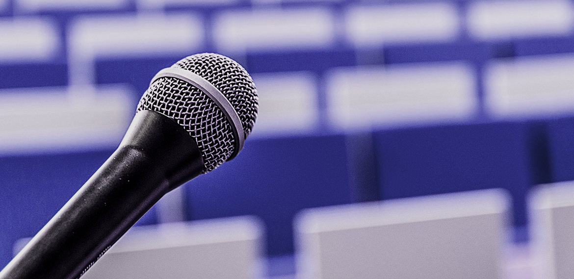 Ein leeres Auditorium mit einem Mikrofon, das den BuildingSMART International Standards Summit symbolisiert.