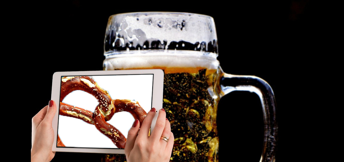 Eine Person hält ein Tablet mit Bier+Brezeln in einer Veranstaltungsreihe.
